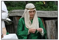 Eine adlige Dame l&aumlsst sich bei der Handarbeit von einer Musikantin unterhalten.